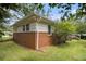 A backyard with a brick and vinyl exterior, featuring a well-kept lawn and partial fence at 2785 Toney Dr, Decatur, GA 30032