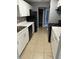 Modern kitchen featuring white cabinets, black appliances, and tiled flooring at 3575 Oakvale Rd # 305, Decatur, GA 30034