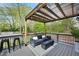 Outdoor deck with overhead covering including a sofa, chairs, and a gas fire pit at 1251 Pierce Ave, Smyrna, GA 30080