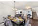 Formal dining room with a dark wood table, grey upholstered chairs, and modern chandelier at 4105 Vista Pointe Dr, Cumming, GA 30028