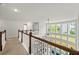 Hallway with wood railing overlooking the living room with large windows at 4105 Vista Pointe Dr, Cumming, GA 30028