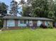 Charming single-story home with brick facade, light blue shutters, and well-maintained front yard at 1487 Colony East Cir, Stone Mountain, GA 30083