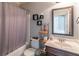 Full bathroom with a shower-tub combo, dark wood vanity, and decorative shelving offers practical functionality at 2183 Trinity Grove Ct, Dacula, GA 30019