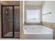 The bathroom showcases a soaking tub, a separate tiled shower, and a window, creating a spa-like atmosphere at 2183 Trinity Grove Ct, Dacula, GA 30019