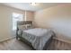 Neutral bedroom features a window with a wooded backyard view and a queen-size bed with stylish, grey-patterned bedding at 2183 Trinity Grove Ct, Dacula, GA 30019