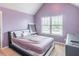 Comfortable bedroom with violet painted walls, carpet, a large window, and sleek furniture creates a serene atmosphere at 2183 Trinity Grove Ct, Dacula, GA 30019