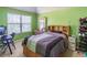 Bright bedroom with green walls features a comfortable bed, a desk, and neutral carpet for a serene space at 2183 Trinity Grove Ct, Dacula, GA 30019