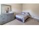 Cozy bedroom featuring neutral walls, a large dresser, and a comfortable bed with patterned bedding at 2183 Trinity Grove Ct, Dacula, GA 30019