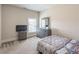 Comfortable bedroom with soft natural light, neutral walls and carpet with a dresser and TV console at 2183 Trinity Grove Ct, Dacula, GA 30019