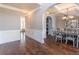 Elegant dining room showcasing wainscoting, an arched doorway, and hardwood floors, ideal for formal dining experiences at 2183 Trinity Grove Ct, Dacula, GA 30019
