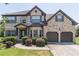 Charming two-story brick home with a well-manicured lawn and an attached two-car garage at 2183 Trinity Grove Ct, Dacula, GA 30019