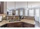 Modern kitchen featuring granite countertops, stainless steel sink, and dark wood cabinetry open to the Gathering room at 2183 Trinity Grove Ct, Dacula, GA 30019