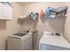 Efficient laundry room equipped with modern front-load washer and dryer units and shelving for storage at 2183 Trinity Grove Ct, Dacula, GA 30019