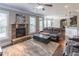 Inviting living room featuring a stone fireplace, ceiling fan, and comfortable seating, perfect for relaxation and gatherings at 2183 Trinity Grove Ct, Dacula, GA 30019