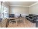 Bright office space featuring a large window, tan carpet, an executive desk and a comfortable black leather couch at 2183 Trinity Grove Ct, Dacula, GA 30019