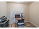 Small home office area with a basic desk, chair, computer, and mini fridge provides a functional workspace at 2183 Trinity Grove Ct, Dacula, GA 30019