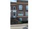 Close-up of a brick townhome featuring an arched doorway and black iron railings at 5139 Peachtree Road, Chamblee, GA 30341