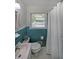 Cozy bathroom features blue tile detail, white sink and toilet, and shower with white curtain at 1403 Dennis Dr, Decatur, GA 30032