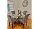 Elegant dining area with glass table, upholstered chairs, and hardwood floors at 1403 Dennis Dr, Decatur, GA 30032