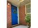 Close-up of bright blue front door with decorative wreath, brick exterior, and sidelight window at 1403 Dennis Dr, Decatur, GA 30032