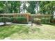 Well-maintained front yard of this brick home, featuring lush greenery, manicured bushes, and a covered parking area at 1403 Dennis Dr, Decatur, GA 30032