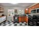 Cozy kitchen with checkerboard floors, wooden cabinets, stainless steel appliances, and backyard view at 1403 Dennis Dr, Decatur, GA 30032