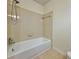 Tiled bathtub and shower combination in the bathroom with neutral tones at 3533 Mulberry Way, Duluth, GA 30096