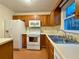 Features an oven, microwave, and cabinets with a window providing light and a double-basin sink at 3533 Mulberry Way, Duluth, GA 30096