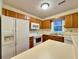 Well-lit kitchen with wooden cabinetry and white appliances at 3533 Mulberry Way, Duluth, GA 30096
