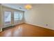 Neutral room with wood floors and white trim, light-filled windows and door at 3533 Mulberry Way, Duluth, GA 30096
