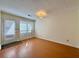 Neutral room with wood floors and white trim, light-filled windows and door at 3533 Mulberry Way, Duluth, GA 30096