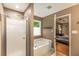 Bathroom featuring a shower, soaking tub, and a view to the adjacent bedroom at 4137 Donna Ct, Ellenwood, GA 30294