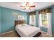 Bedroom features a ceiling fan, beautiful paint color, and large windows at 4137 Donna Ct, Ellenwood, GA 30294