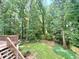 Lush backyard view from the deck, showcasing green space and mature trees for outdoor enjoyment at 1435 Great Oaks Dr, Lawrenceville, GA 30045