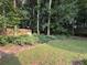 Lush backyard with mature trees and green grass at 1435 Great Oaks Dr, Lawrenceville, GA 30045