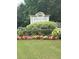 Community sign surrounded by colorful flowers and greenery, creating a welcoming entrance at 1435 Great Oaks Dr, Lawrenceville, GA 30045