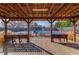 View of the community tennis court from the covered seating area featuring benches and a wooden deck at 1435 Great Oaks Dr, Lawrenceville, GA 30045