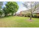 Spacious backyard featuring a well-maintained lawn, mature trees, and a brick patio with outdoor seating at 535 Brickleberry Ln, Roswell, GA 30075