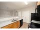 Open kitchen featuring granite countertops, black appliances, and a double sink at 6010 Capitol Knl, Fairburn, GA 30213