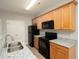 Beautiful kitchen boasts granite countertops, wood cabinetry, and modern black appliances at 6010 Capitol Knl, Fairburn, GA 30213