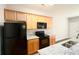 Well-equipped kitchen with granite countertops, wood cabinets, and essential black appliances at 6010 Capitol Knl, Fairburn, GA 30213