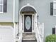 Close-up of home's entrance featuring covered porch, oval glass door, and white trim at 1735 Silver Way, Lithia Springs, GA 30122