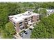 Aerial view of brick building complex surrounded by lush trees and a parking area at 790 North Ne Ave # 209, Atlanta, GA 30306