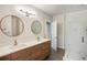 Modern bathroom featuring a double vanity, sleek fixtures, round mirrors, and a glass-enclosed shower with white tile at 790 North Ne Ave # 209, Atlanta, GA 30306