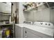 Functional laundry room featuring a washer, dryer, storage shelves, and utility connections at 790 North Ne Ave # 209, Atlanta, GA 30306