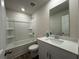 Well-lit bathroom features a shower-tub combo and modern vanity with granite countertop at 1601 Dosk Ave, Lawrenceville, GA 30044