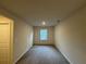 A cozy carpeted bedroom with neutral walls and a bright window with views to the exterior at 1601 Dosk Ave, Lawrenceville, GA 30044