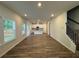 Bright open-concept living space with hardwood floors, a kitchen, and access to the upper level at 1601 Dosk Ave, Lawrenceville, GA 30044