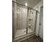 Enclosed walk-in shower with large-format tile, corner shelf, and glass door at 1601 Dosk Ave, Lawrenceville, GA 30044