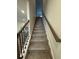 Carpeted stairway with wooden handrail and dark-stained newel posts leads to the upper level at 1601 Dosk Ave, Lawrenceville, GA 30044